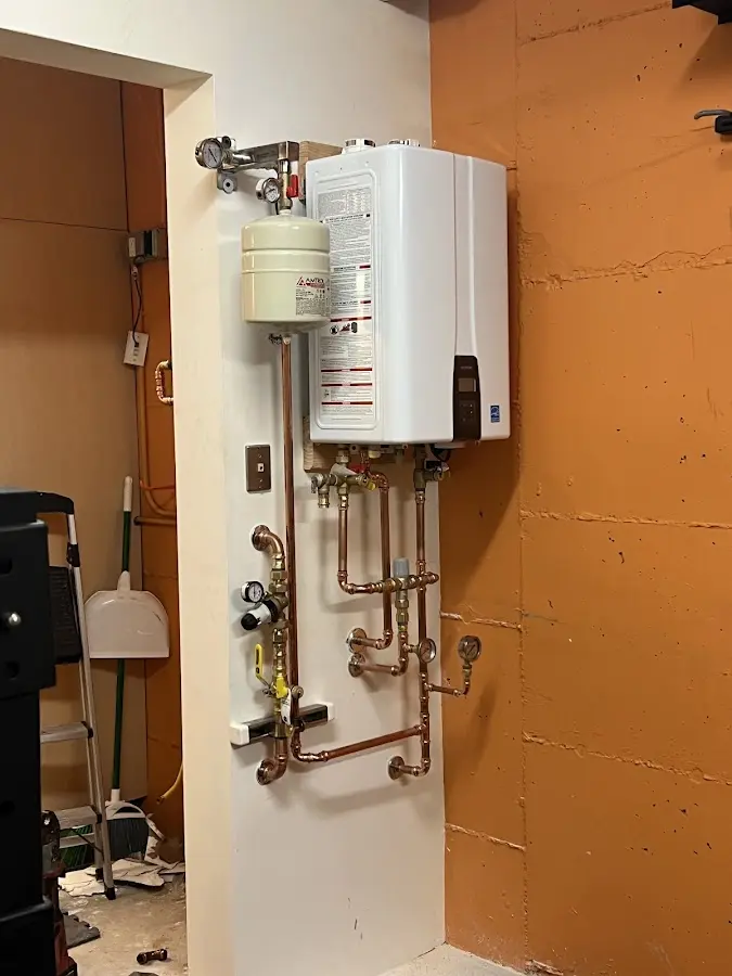 Plumbing technician inspecting water heater connections in Hurricane